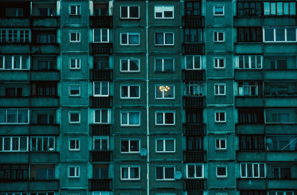 The Art of Drawing Readers In: Your attractive post title goes here Detailed view of a symmetrical urban apartment building facade with a cold color palette.