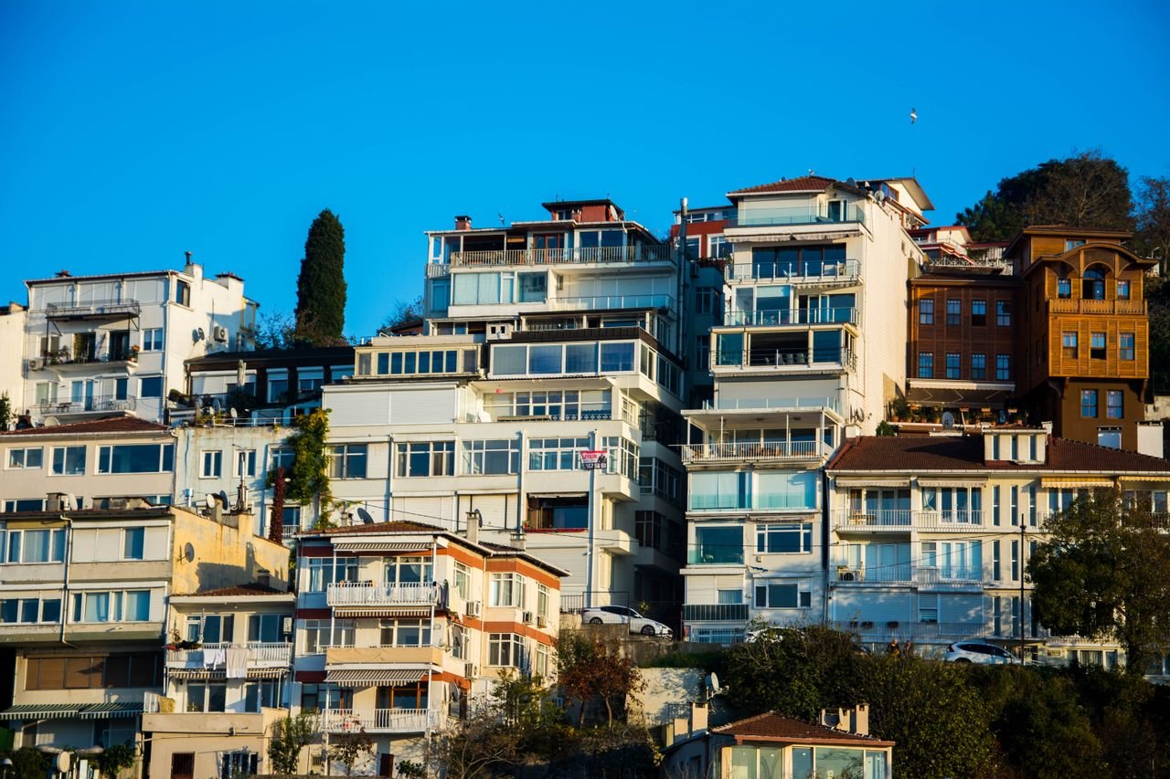 Mastering the First Impression: Your intriguing post title goes here Captivating view of hillside residential buildings under a vibrant blue sky, showcasing modern architectural design.
